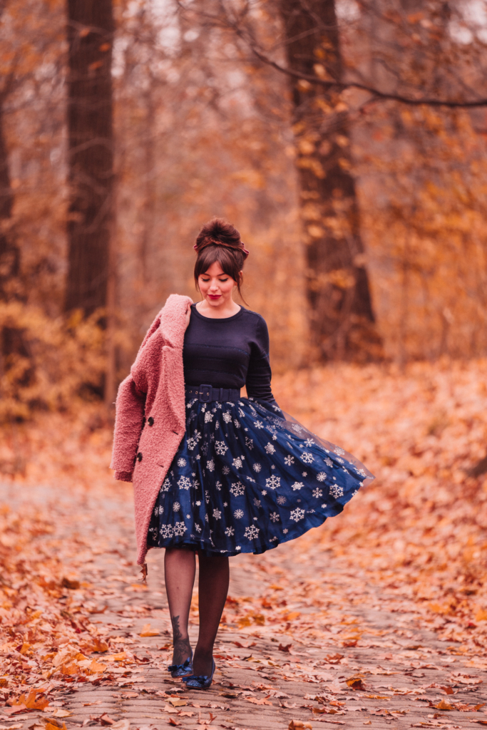 woman wearing blue sweater and printed skirt