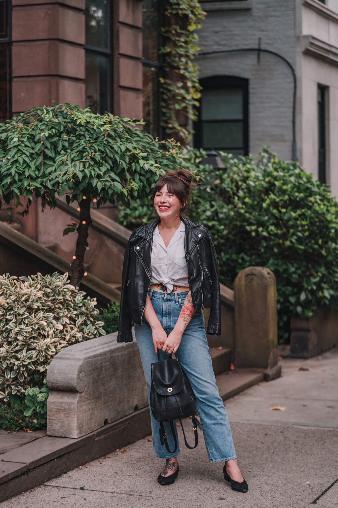 woman wearing white shirt, denim jeans, and leather jacket