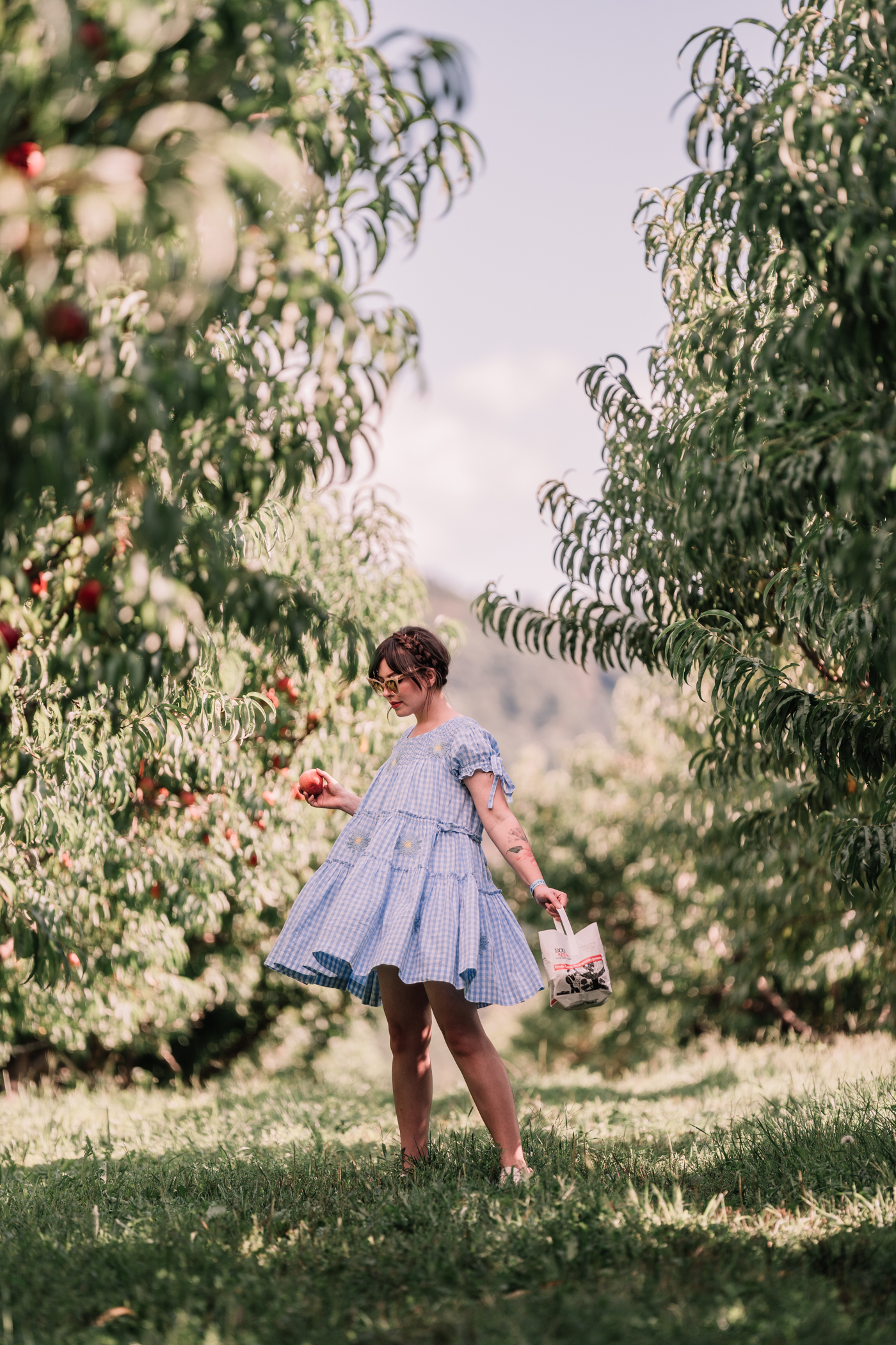 woman picking pears and wearing blue dress for one day two looks