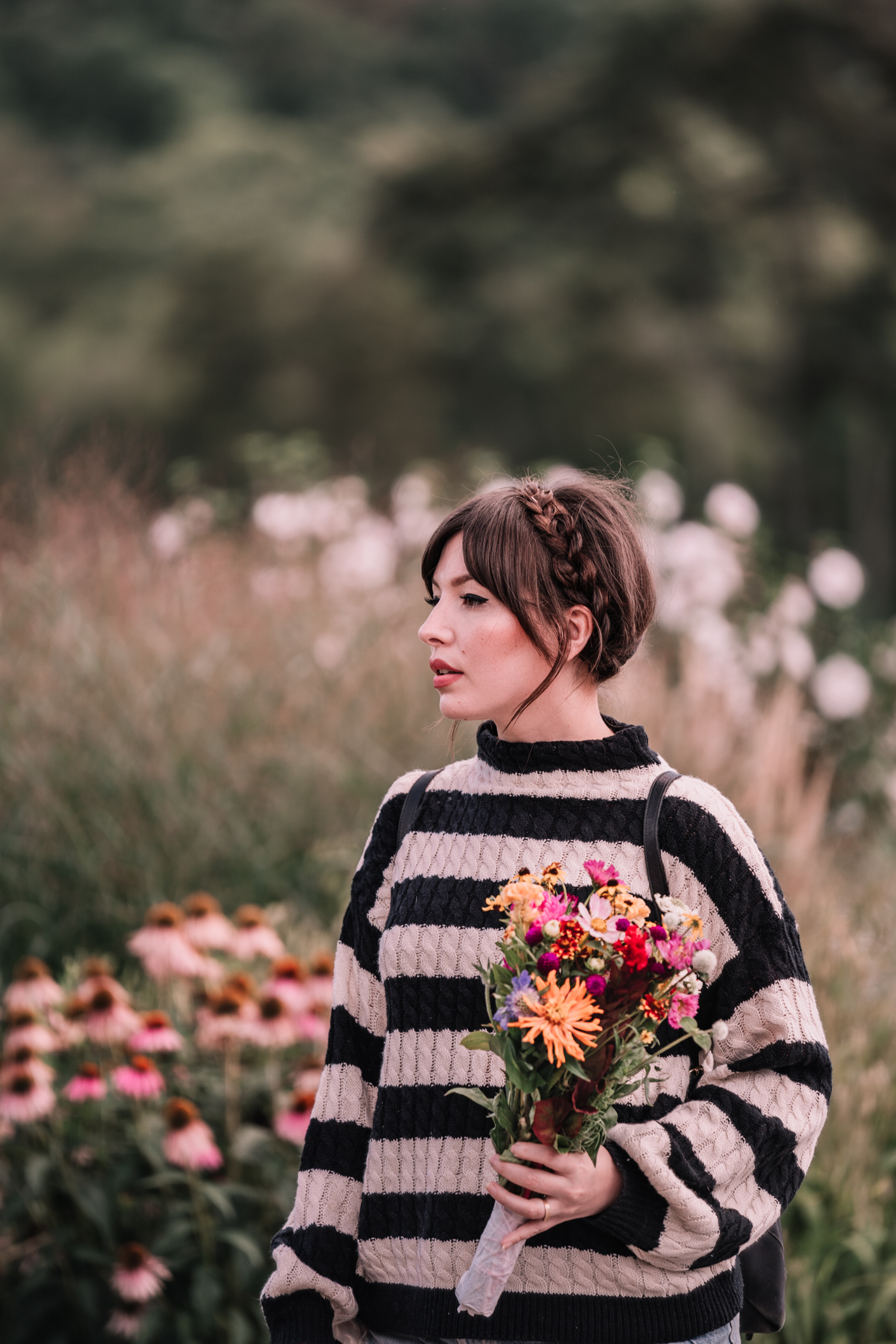 woman wearing black and white sweater and holding flowers for one day two looks