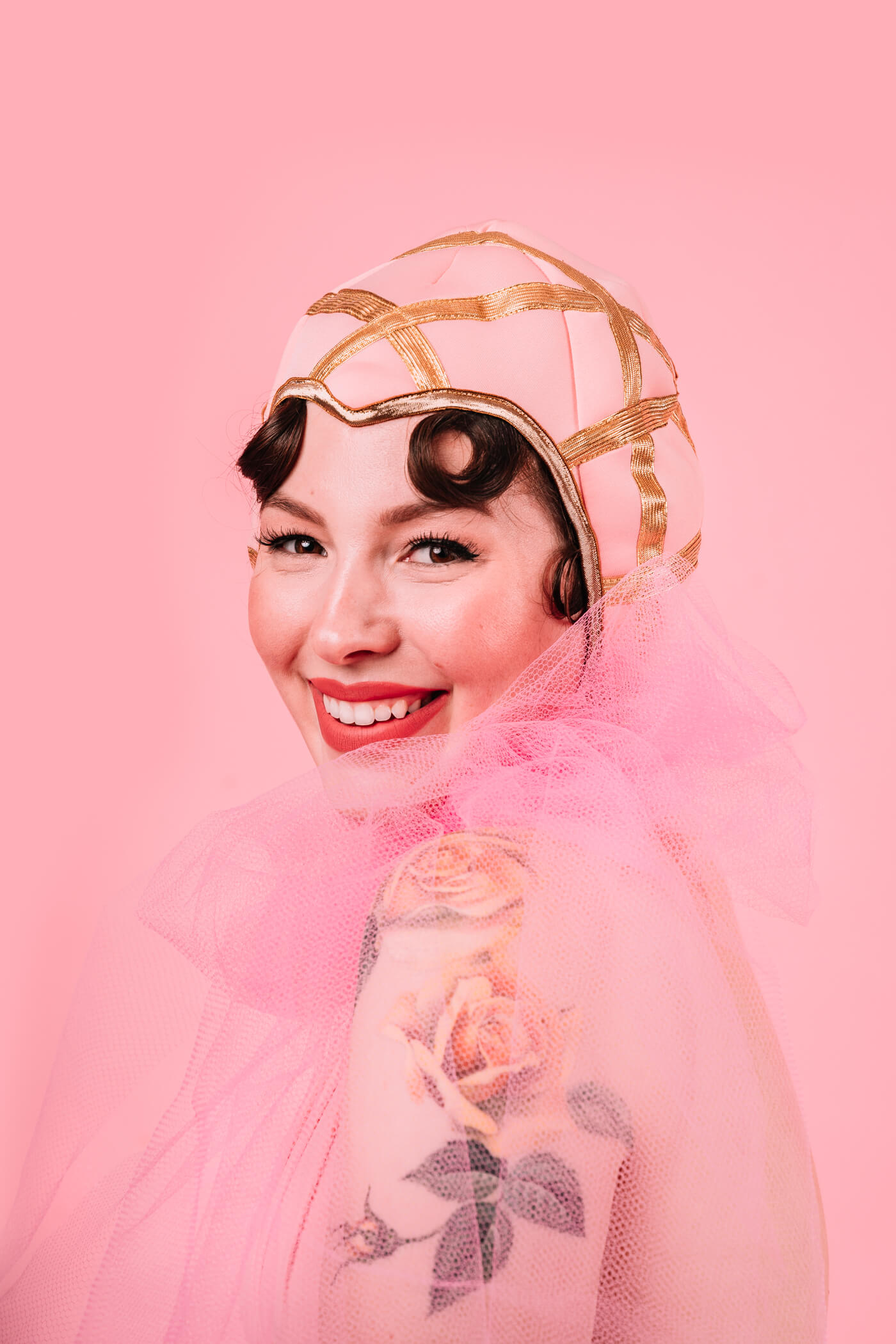 woman wearing a pink veil and smiling