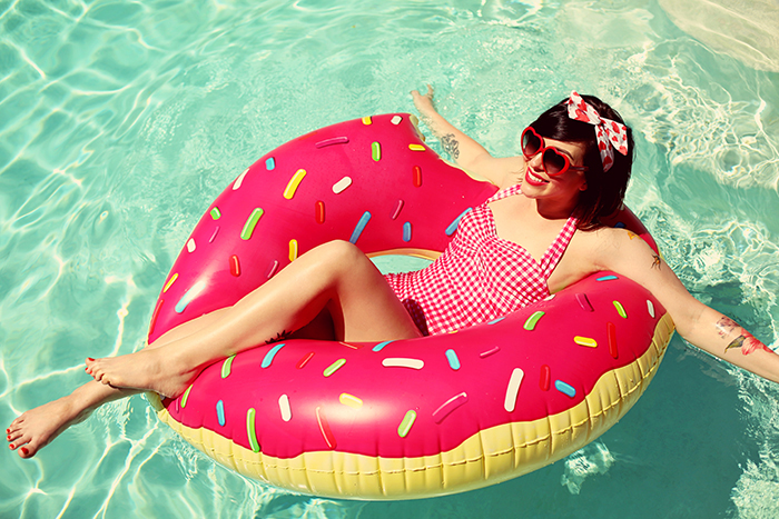 woman wearing retro gingham swimsuit and floating in a donut float for 2015 roundupa