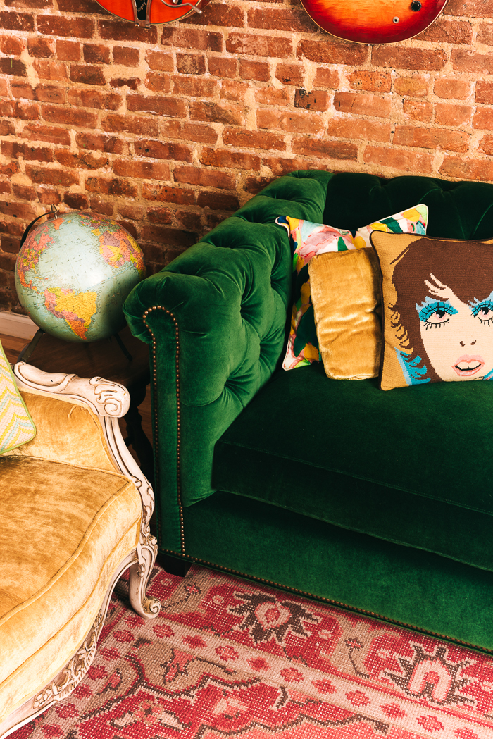 Green Velvet Tufted Sofa And Pink Rug