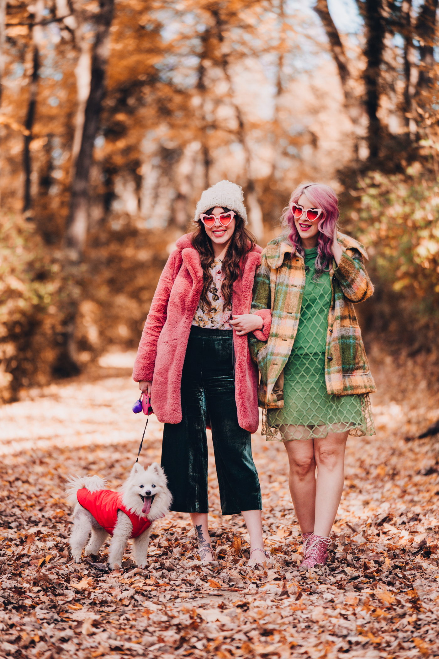 woman in pink faux fur coat and green dress and jacket with her dog