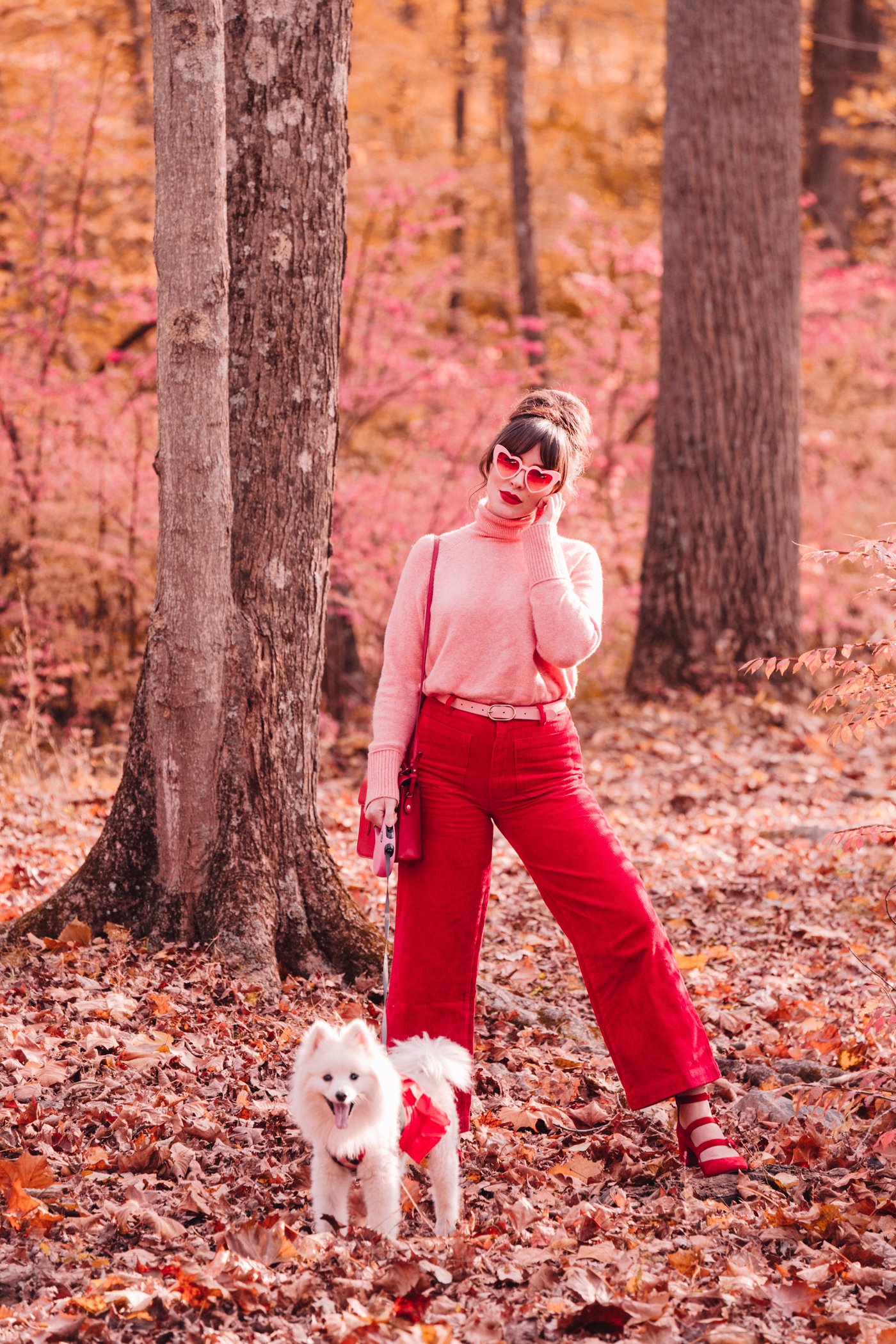 woman wearing pink and red top and pants with her dog