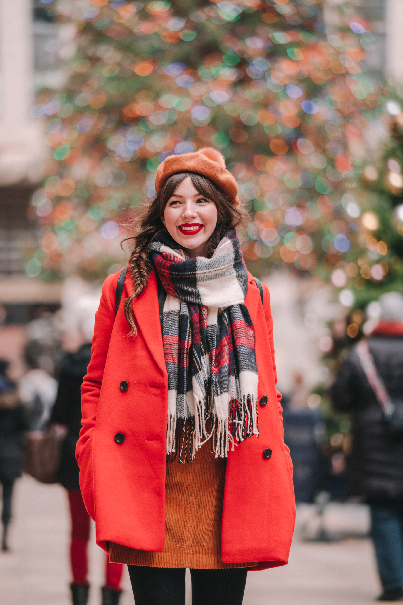 woman smiling and wearing red moto jacket and sharing it's beginning to look a lot like Christmas