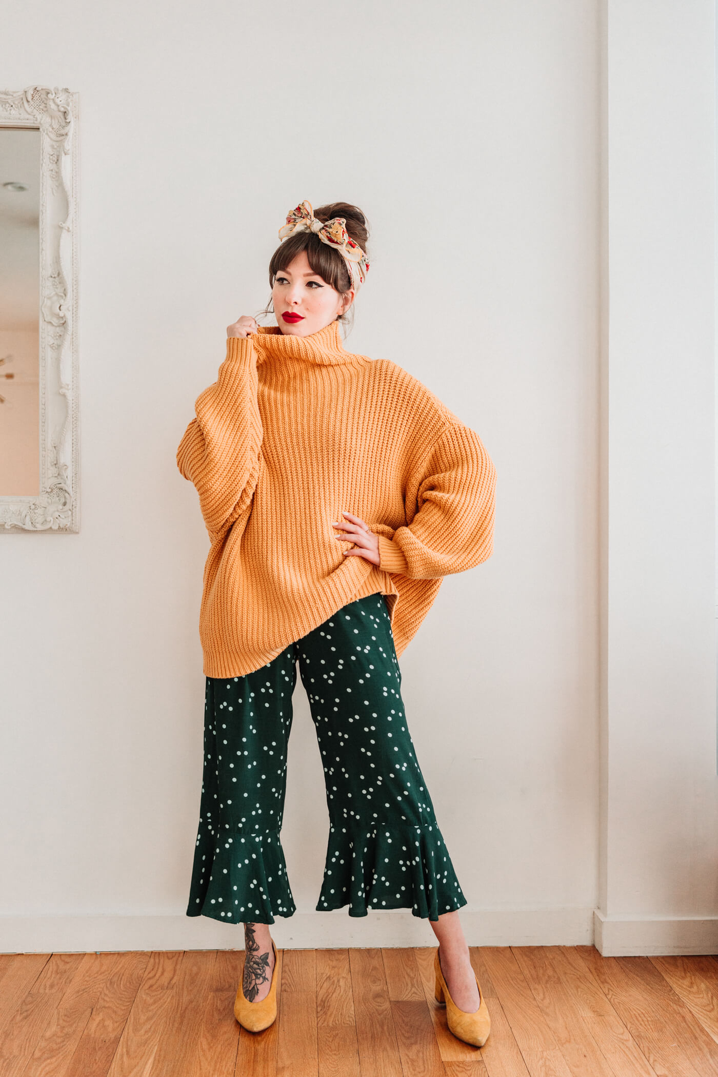 woman wearing green and polkadot jumpsuit with sweater 