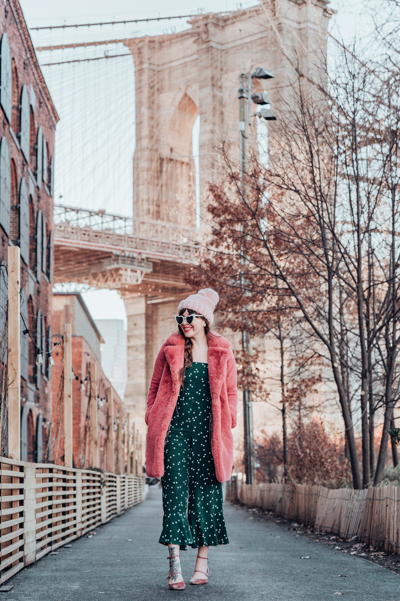 woman in green printed dress and pink coat 