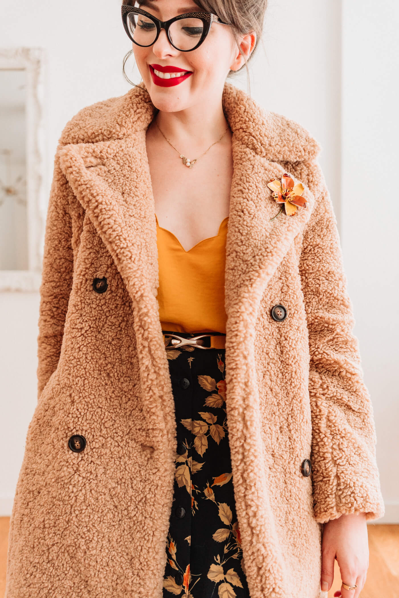 woman in yellow top and printed skirt  with teddy coat