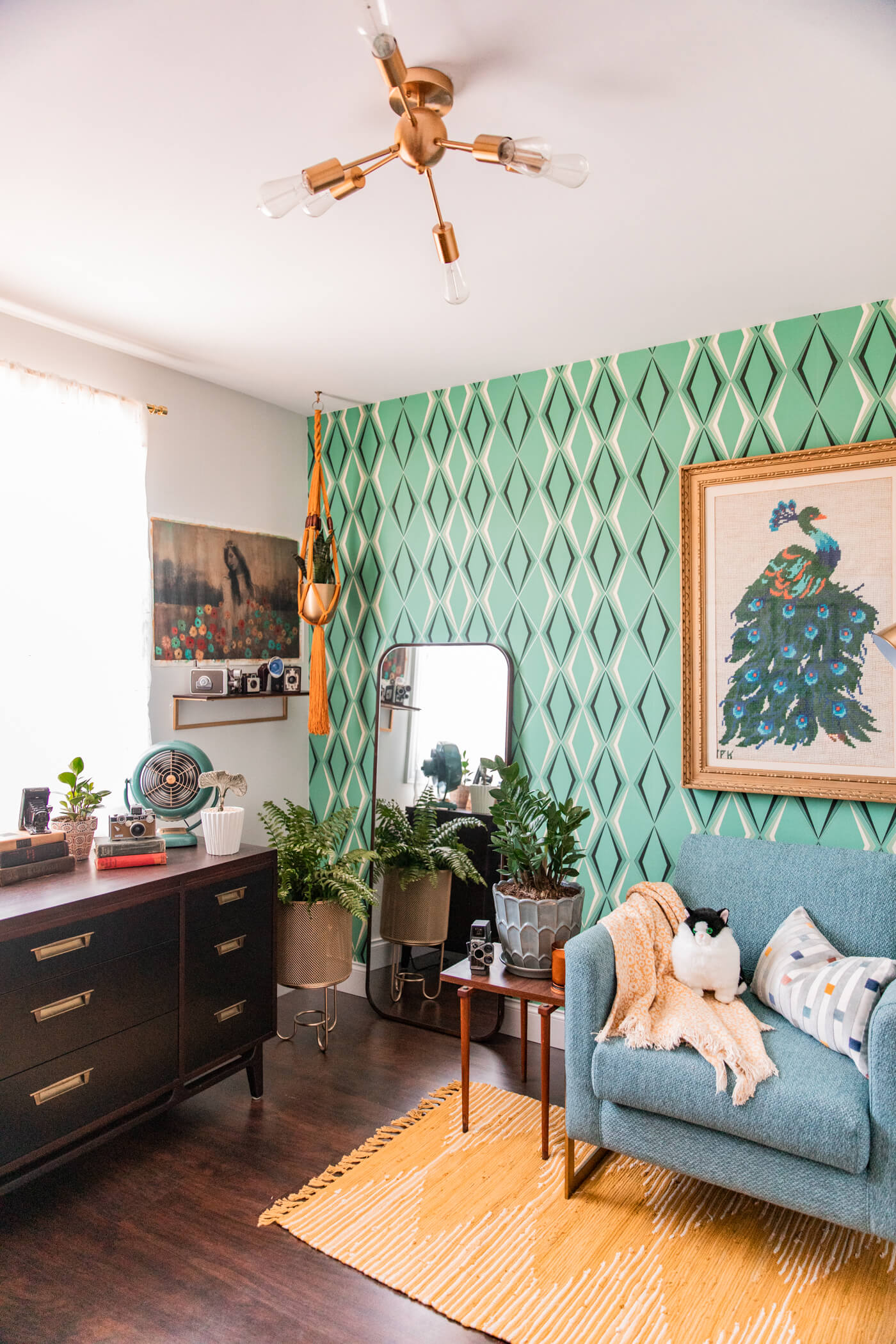 a room with painted accent wall, gold chandelier, and home decorations for HomeGoods Home Office Makeover