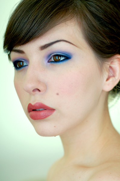 face of a woman wearing blue signature eye makeup 