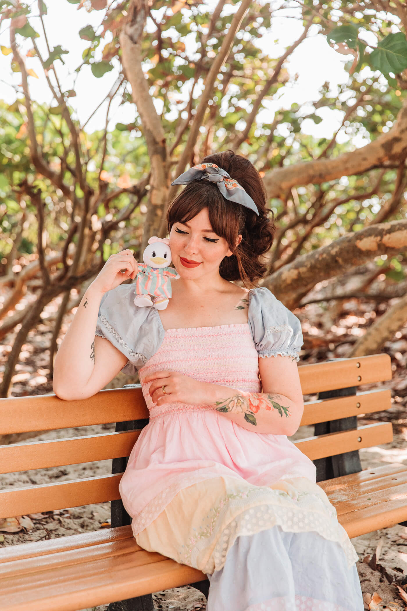 woman at the beach holding a duck stuffed to and wearing pastel dress for nuiMOs Outfits