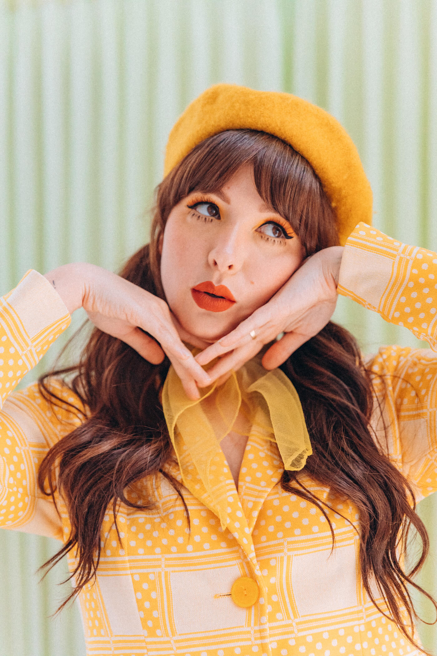 woman wearing yellow clothes, yellow hat, and has Fake Lower Lashes