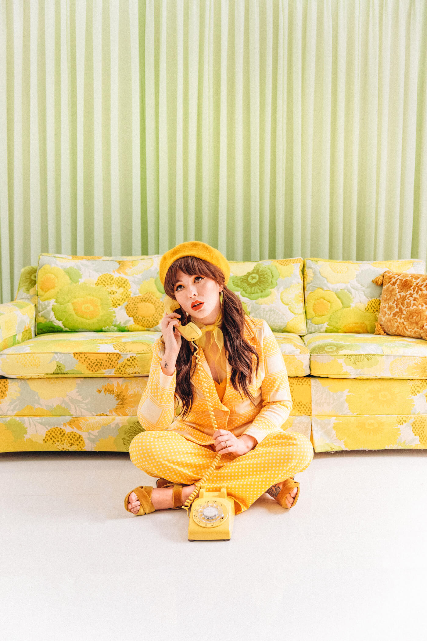 woman using a telephone and wearing a yellow leisure suite for past lives of future heirlooms post
