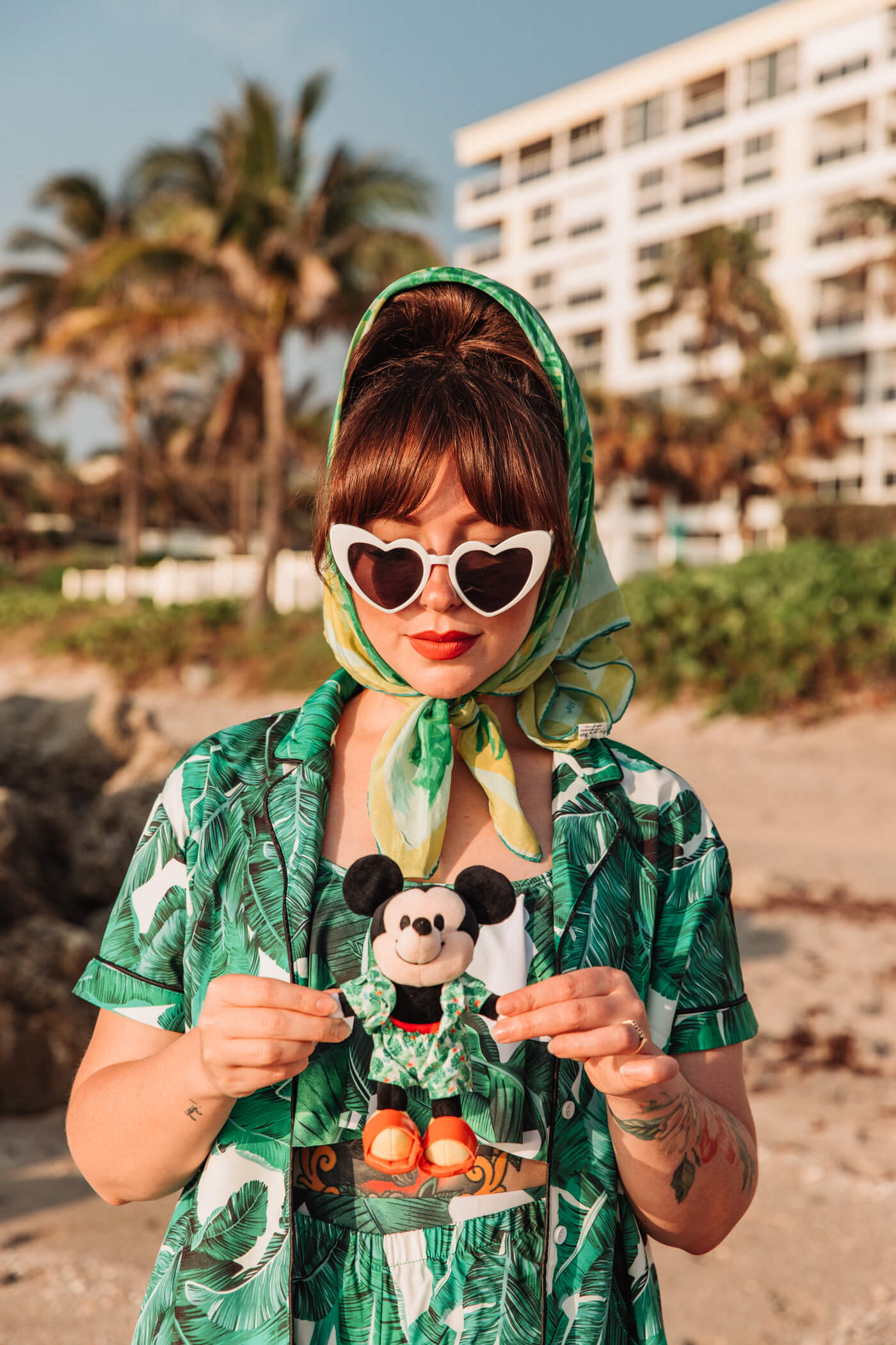 woman at the beach wearing heart-shaped sunglasses and green dress with leaves print for nuiMOs Outfits