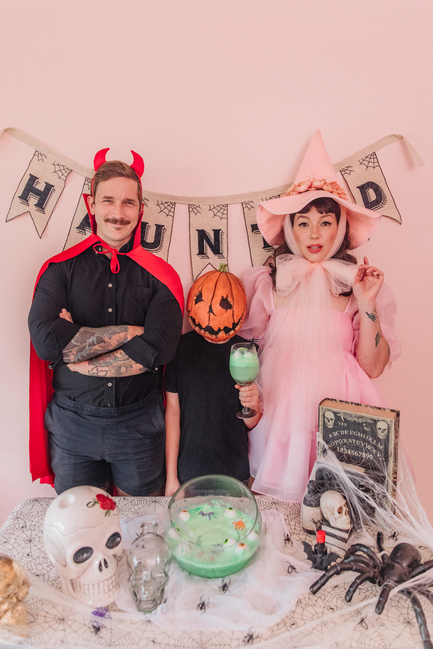 a couple with a kid sharing halloween Witches Brew punch recipe