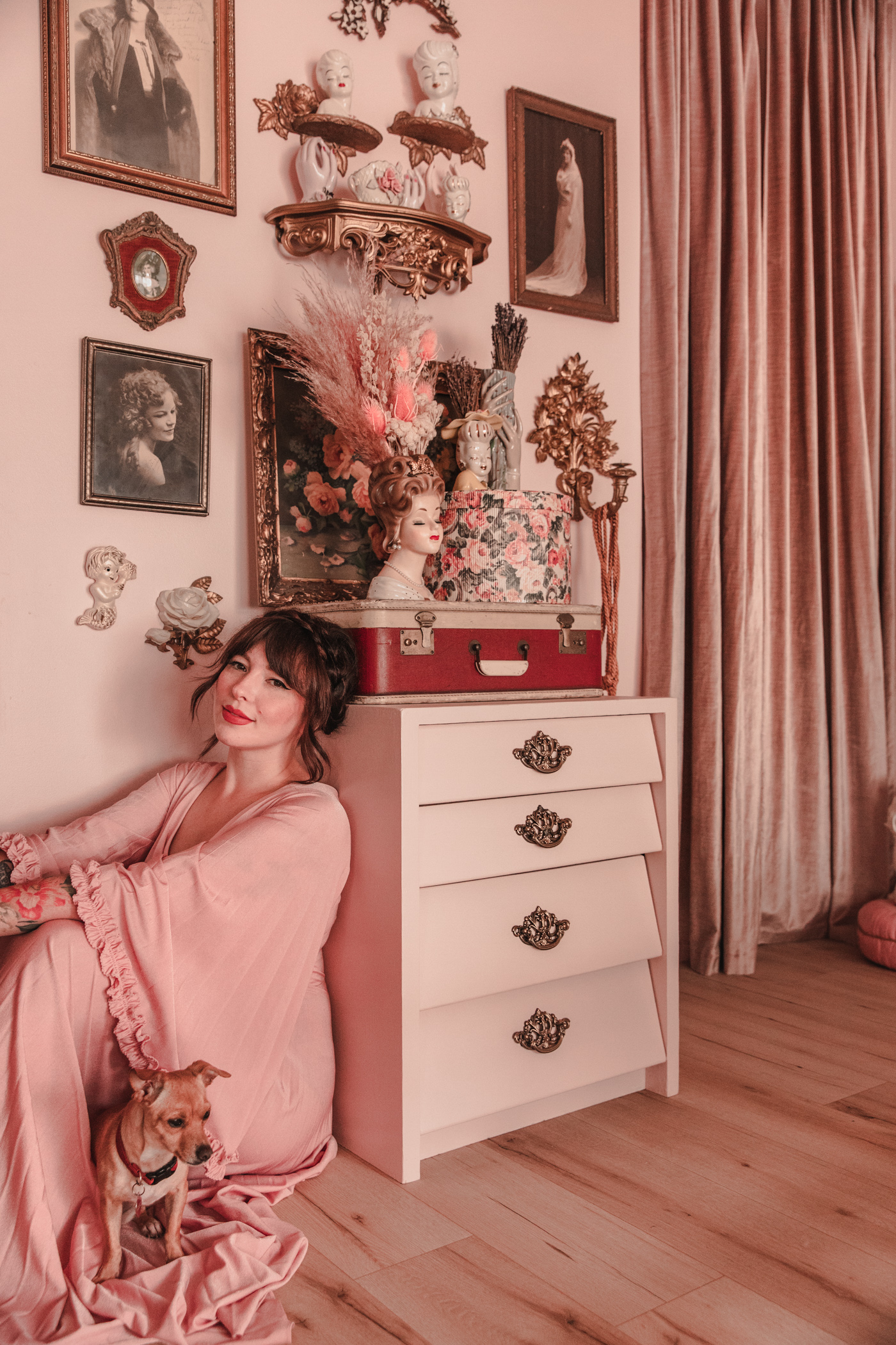 woman sitting beside a a dresser and sharing vintage dresser makeover