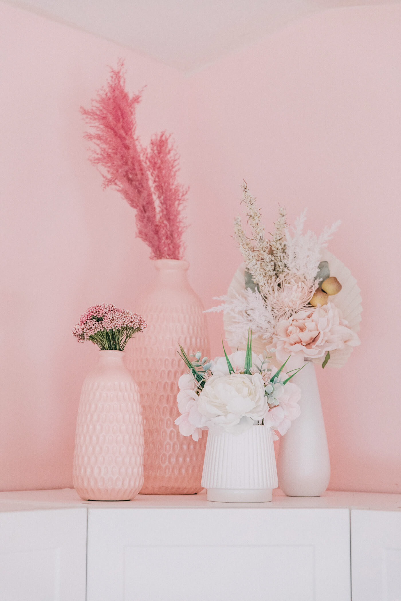 pink and white vases and flowers