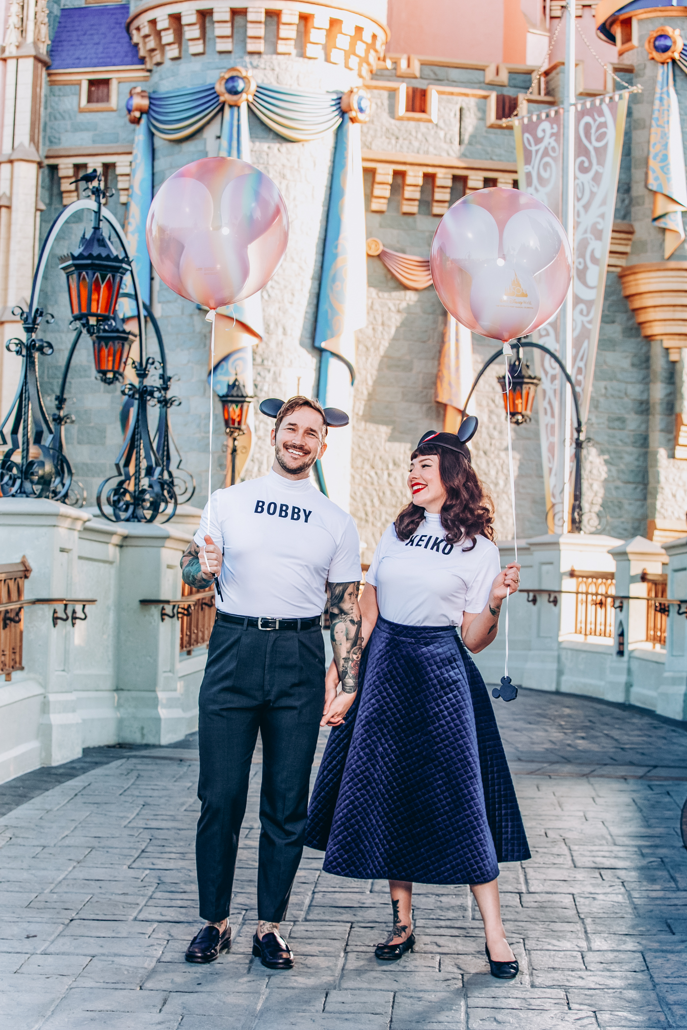 a couple holding balloons in their private photo shoot at disney
