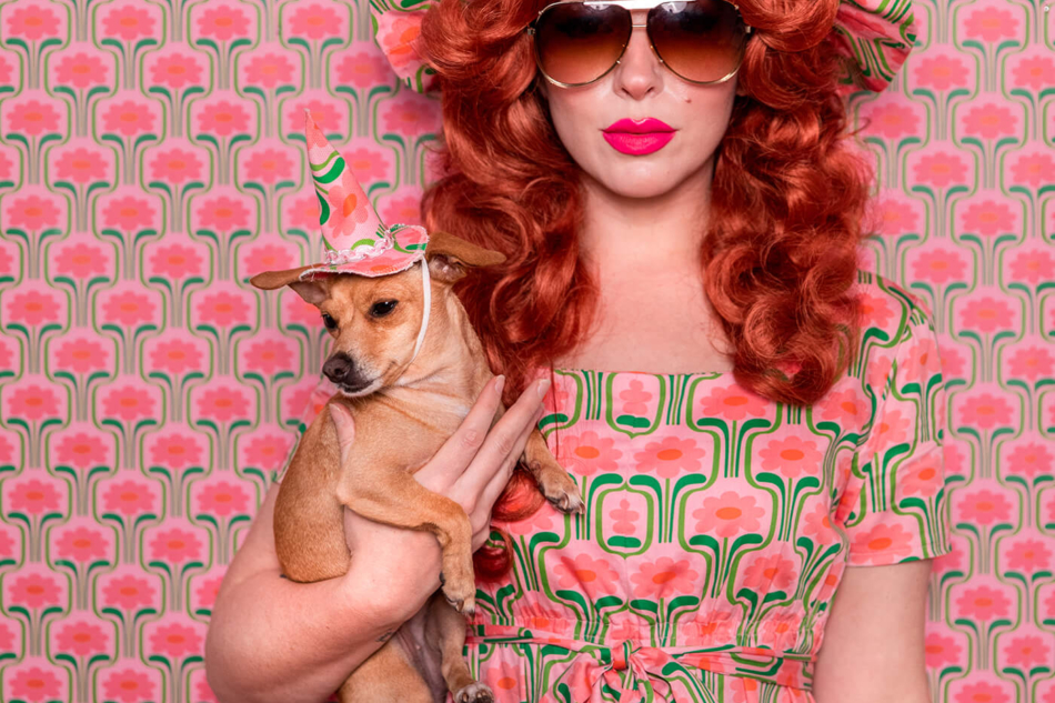 Keiko Lynn wearing a handmade dress and matching witch hat made out of Spoonflower fabric, in front of matching wallpaper in the same print.